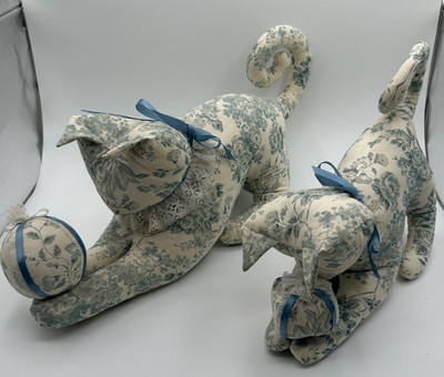 two handmade plush cat figures with matching balls playful kitties curly tails