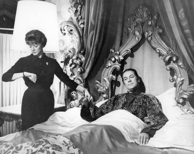 Maggie Smith takes Rex Harrison's pulse as he lays in bed in the f- Old Photo