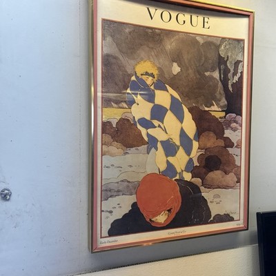 Vintage Print of The Vogue Magazine Cover Against A Dark Windy Landscape.