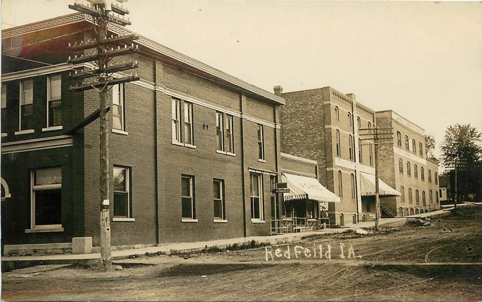 c1910 RPPC Street Scene State Bank of Redfield IA Grocery Store & Dr