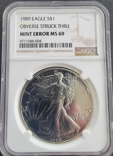 1989 1 OZ AMERICAN SILVER EAGLE COIN - NGC MINT ERROR MS-69 OBVERSE STRUCK THRU