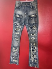 blue denim cargo jeans feature heavy distressing and large utility pockets