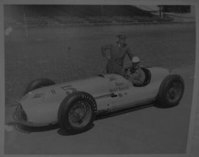 Rex Mays sits in the #5 Novi Mobil Special as another man stand 1949 Indy Photo