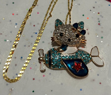 Collar/alfiler avión gatito tono dorado con cristales azules