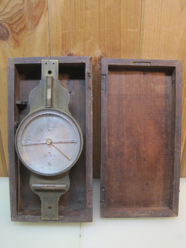 An 1860s brass surveyor's compass by J. Prentice of New York, complete with original wooden case — a genuine American antique that's both beautiful and historically loaded.