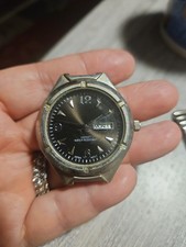 vintage quartz sport wristwatch featuring a dark sunburst dial with a...