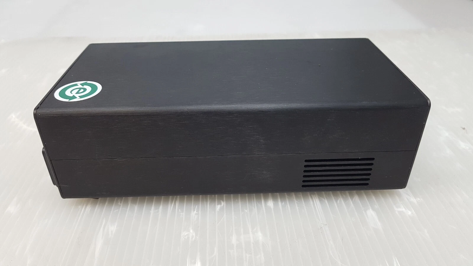 Black aluminum case of the Vortex power supply, side vents