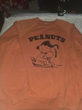 PEANUTS UT Sweatshirt features a vintage-style graphic of Charlie Brown hugging