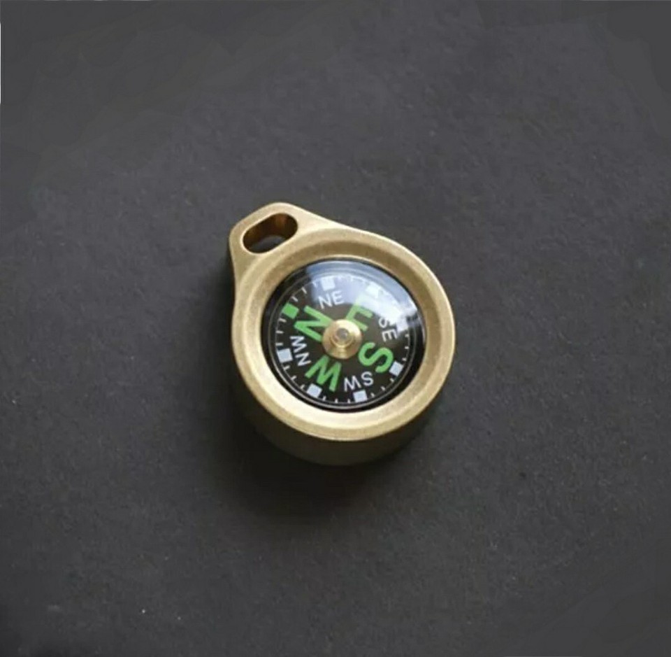 Solid brass mini compass with a pendant loop — equal parts functional EDC tool and vintage-aesthetic jewelry piece.