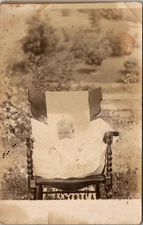 Baby in Wooden Chair in Field Postcard RPPC