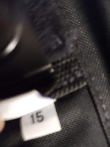 Black nylon IWB holster with white label, number 15, showing front zipper and white stitching.