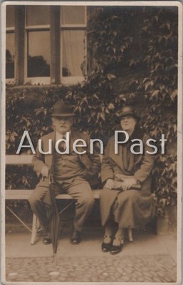 Vintage RPPC älteres Paar auf Bank Mann mit Regenschirm Efeu Gebäude Postkarte