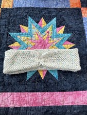 A knitted adult headband, speckled/variegated, made with cotton and acrylic yarn