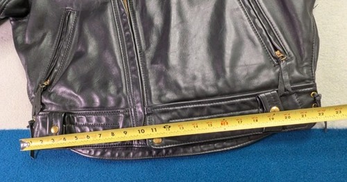 Black vintage leather Langlitz motorcycle jacket with front zipper, two slit pockets, and yellow measuring tape across the back.