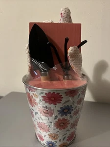 Petits outils de jardin comprenant des gants situés à l'intérieur du conteneur en métal.