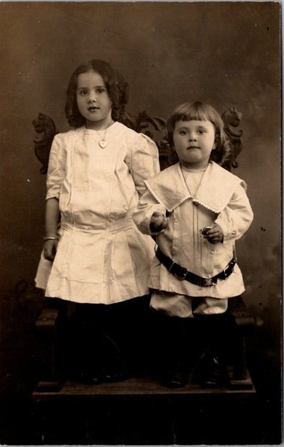 Adorabile fratello e sorella in piedi sulla sedia RPPC - Foto 1 di 2