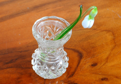 A small crystal vintage vase with a snowdrop made of colored glass. USSR 1970s