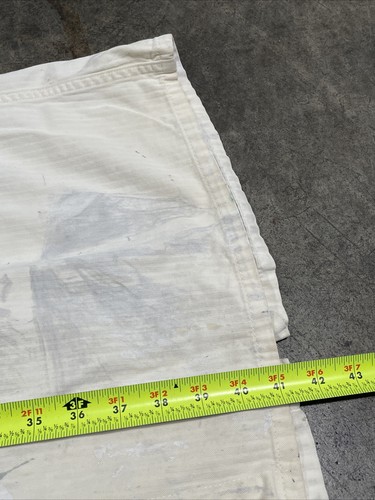 White vintage painters smock work wear canvas coat size 40 with yellow measuring tape across the lower edge.