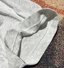 Gray fabric single stitch made in USA, folded with red and orange textured surface.