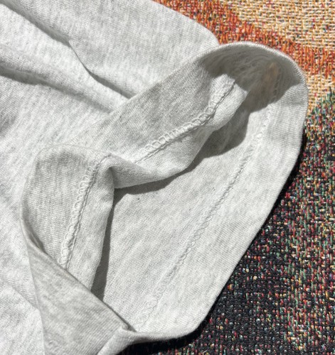 Gray fabric single stitch made in USA, folded with red and orange textured surface.
