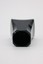 Black hexagonal Creed Aventus bottle cap with smooth curved edges and central circular opening on white background.
