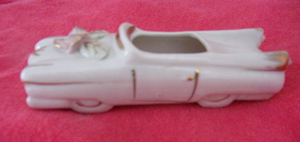 A ceramic car repurposed as a novelty planter — retro kitsch meets unexpected greenery in one conversation-starting desk piece.