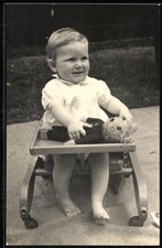 Fotografie Kleinkind mit Teddybär im Laufgestell 