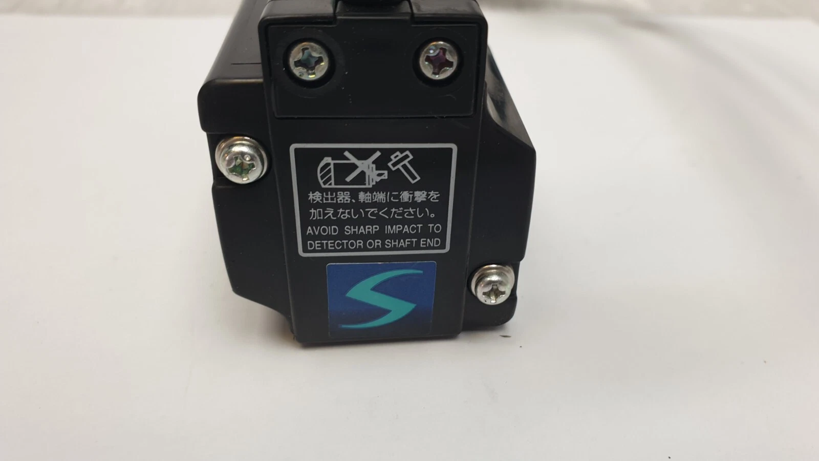 Rear encoder cover of the HC-KFS053K with the avoid-sharp-impact warning label