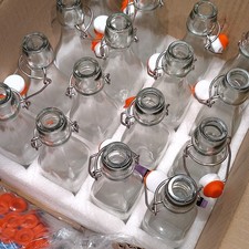 16 Clear Glass Swing-Top Bottles w/ Orange/White Stoppers, Metal, Boxed