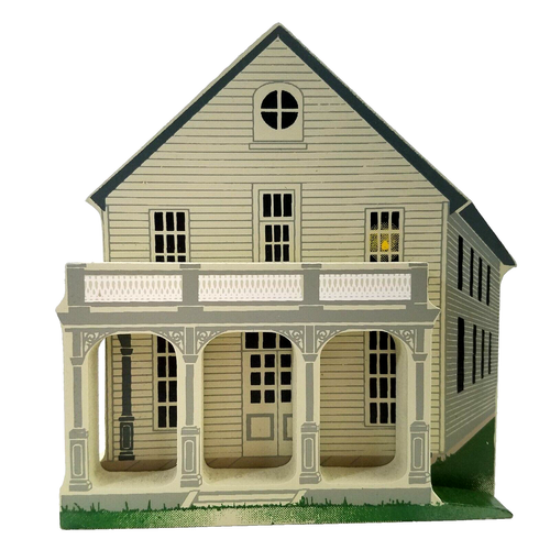 Light gray wooden house with tall pillars, front porch, and windows on a grassy green background.