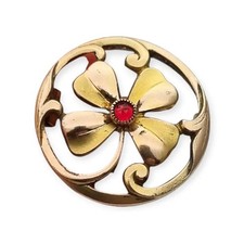Broche Art Nouveau en metal dorado y cristal rojo facetado siglo XX