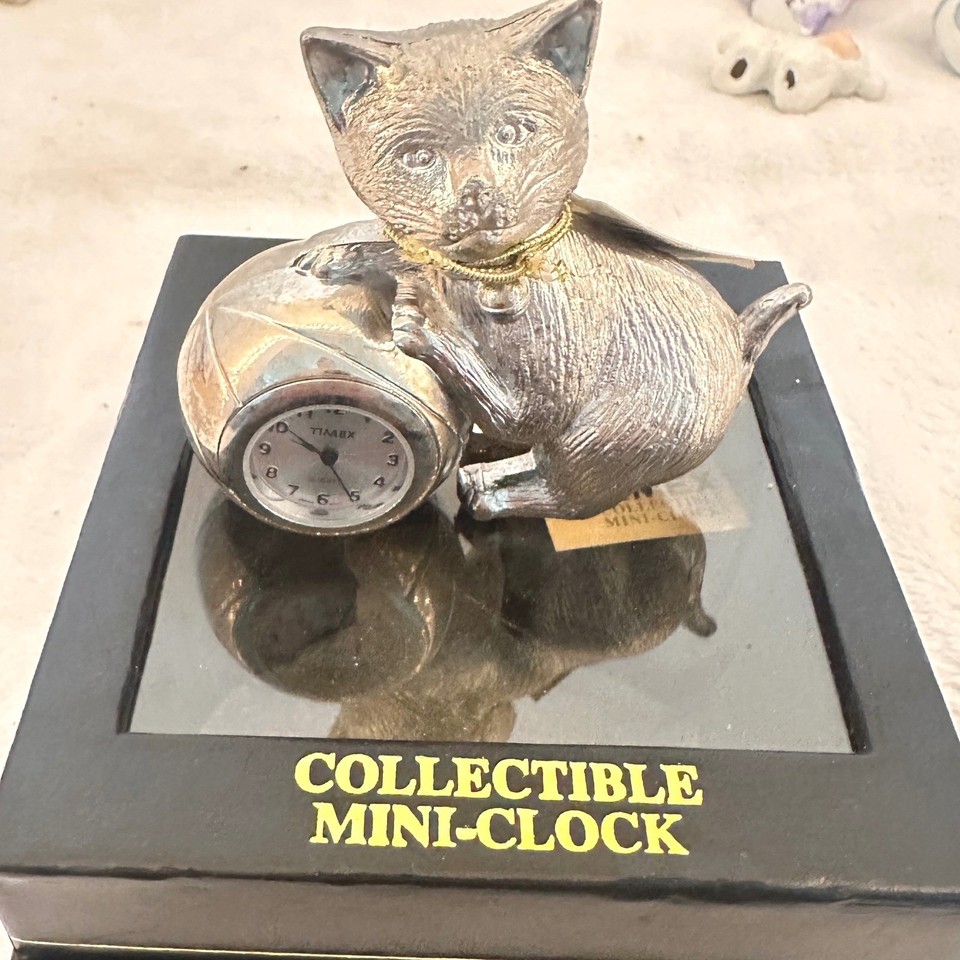 A pewter Timex miniature kitten-with-yarn-ball quartz clock — a delightfully tiny collectible timepiece with old-school charm.