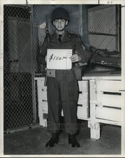 Foto de prensa 1952 soldado en uniforme con casco y pistola tiene letrero de precio de $150