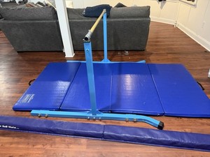 Gymnastics Metal  Bar with Blue Folding Landing Mats, along with a balance beam!