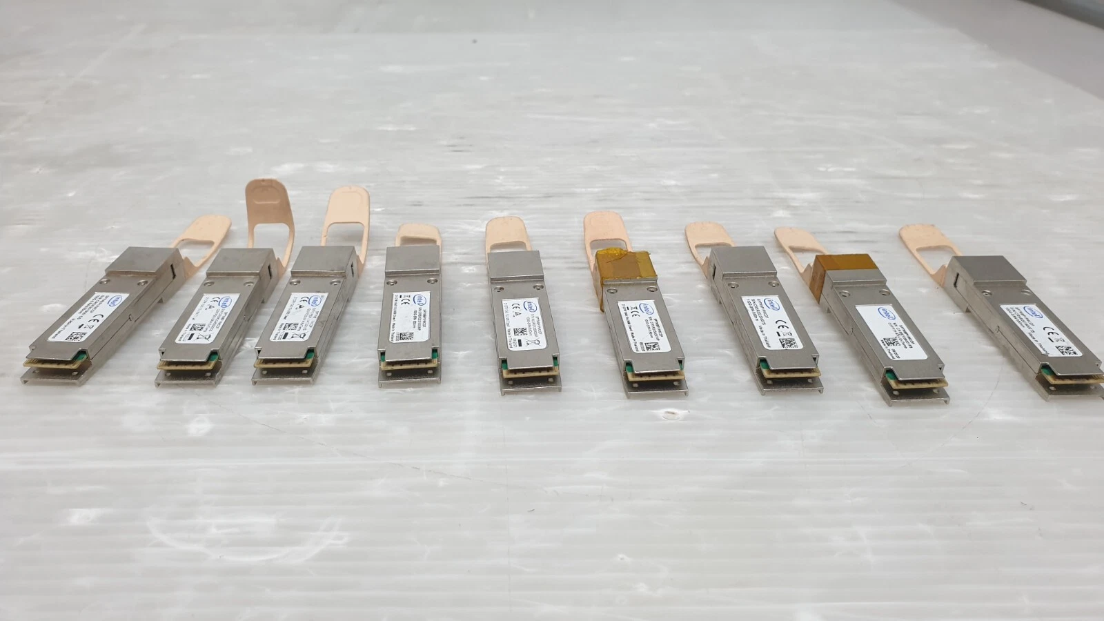 Row of Intel SPTMBP1PMCDF QSFP28 modules showing the electrical edge connectors
