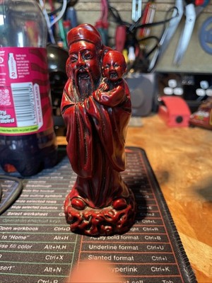 Asiatisch inspirierte rote Harzfigur älter hält Kind detaillierte dekorative Statue