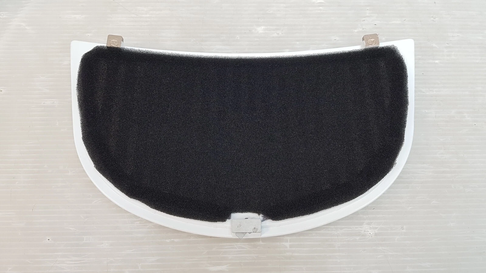 Back of the panel: black foam filter pad and metal retaining clips