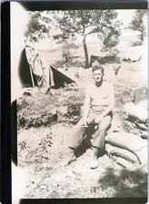 WW2 Photo of Shirtless Soldier Sitting at Camp with Tents