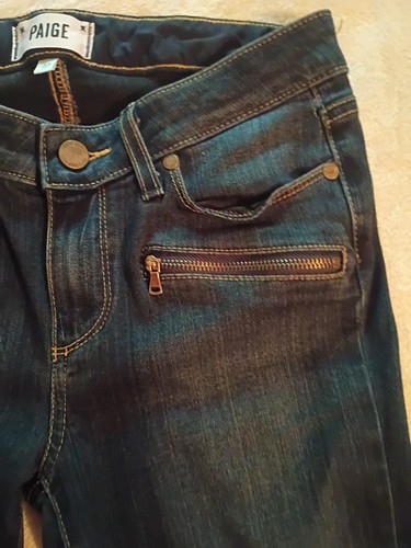 Dark denim jeans with front pockets, round button closure, and “PAIGE JEANS LAUREL CANYON” label on waistband.