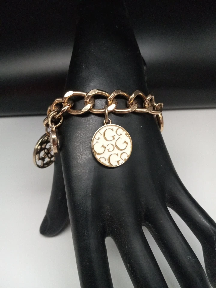 Pulsera GUESS BRAND Logotipo Tono Dorado Cristales Transparentes Esmalte Dijes Palanca Foto 2 de 4