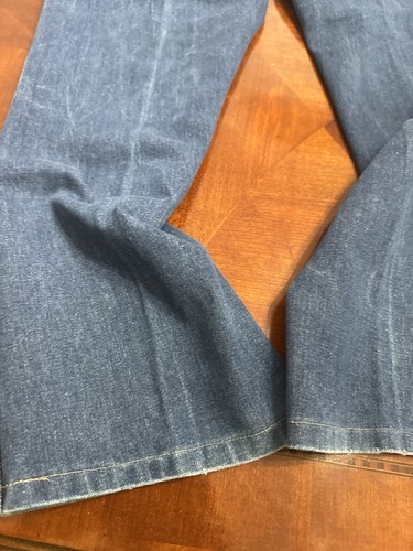 Faded blue vintage Wrangler jeans, size 36x30, with reinforced seams and yellow stitched edge detail on fabric.
