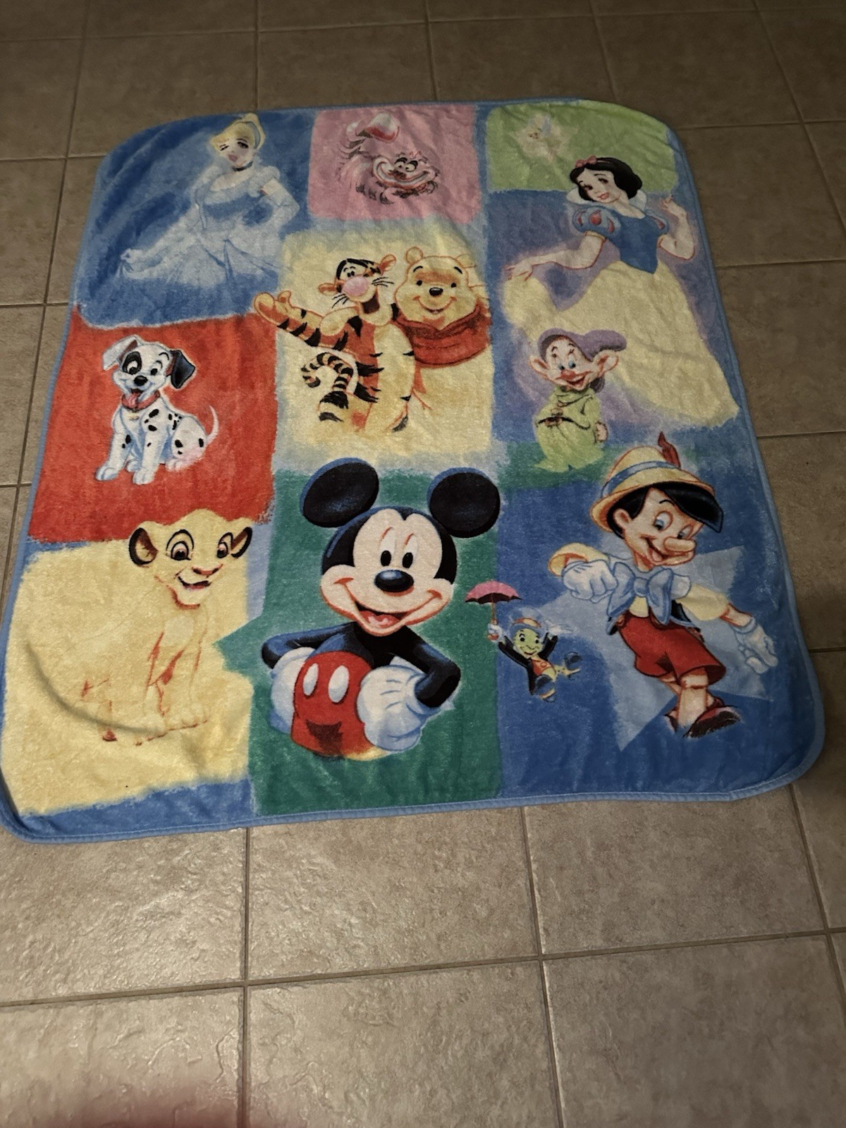 A vintage fleece throw blanket featuring a collage of classic Disney characters.