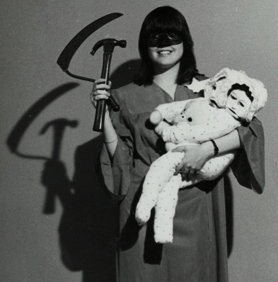 A genuinely bizarre vintage Halloween prop lot — lady face mask, sickle, scythe, hammer, and creepy dolls — the kind of outsider-art haunted-house chaos you can't manufacture.