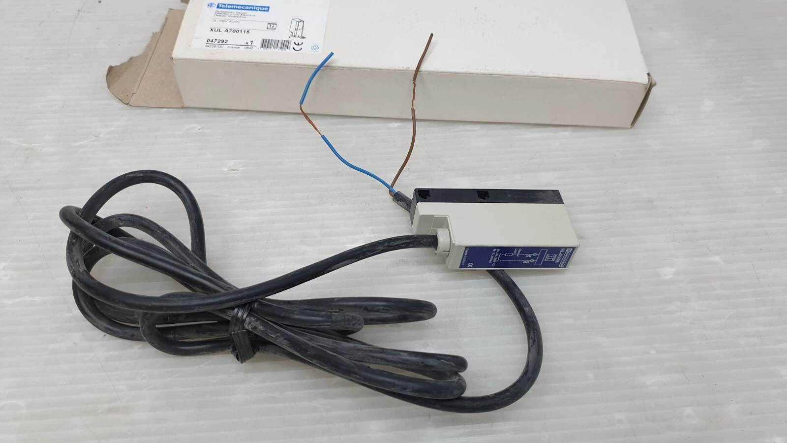 Telemecanique XULA700115 sensor with 2 m black cable in front of its box