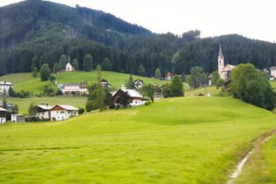 Wandbild: Alpiner Sommerfelder und traditionelle Holzhäuser Blick auf ein [...]