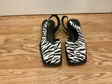 This is a pair of zebra print, square-toe, slingback flats.