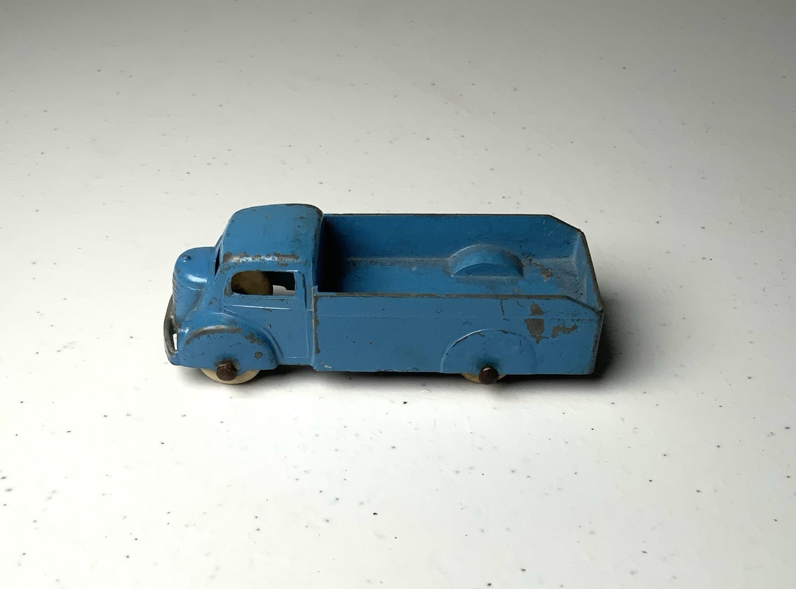 Blue vintage Tootsietoy #234 box truck with worn paint, silver wheels, and “Made in U.S.A.” text on top.