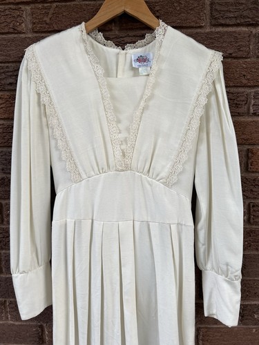 White vintage 70s midi prairie dress with lace neckline, long sleeves, and fitted waist pleats, size 10 USA made.