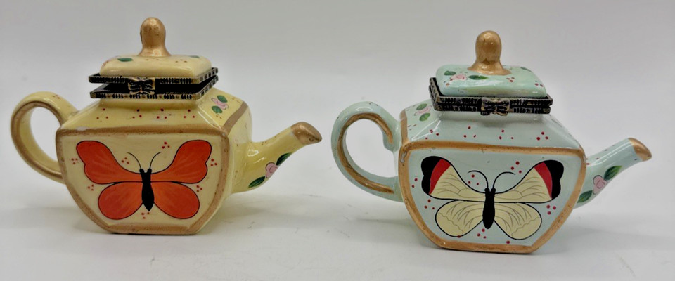 A hand-painted vintage teapot-shaped trinket box set with butterfly motifs in yellow, blue, and gold — the kind of delicate, one-of-a-kind find you can't get from any retailer.