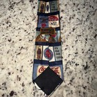Blue necktie with vintage red and white Coca Cola ads, cartoon panels, and white “It’s the real thing” text.